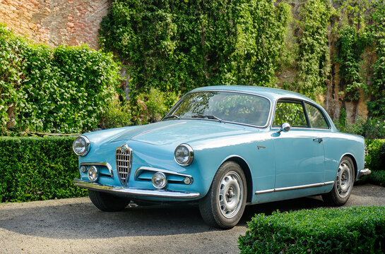 classic blue Alfa Romeo Giulietta Sprint photographed 3/4 in Italian-style garden