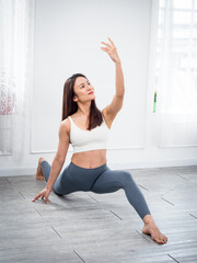 Fototapeta premium Attractive beautiful Asian women practice the pose during their yoga class in a gym. Two women practice yoga together.