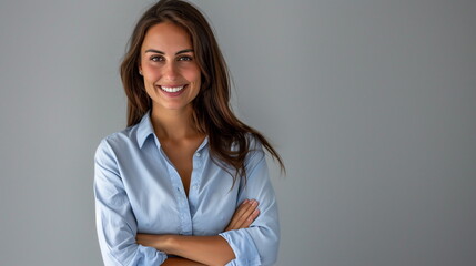 Happy young smiling confident professional business woman wearing blue shirt, happy pretty female executive looking at camera, standing arms crossed isolated at gray background, portrait.