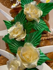 Pastry: close-up of stretched sugar roses, yellow roses with their green foliage to decorate cakes.
