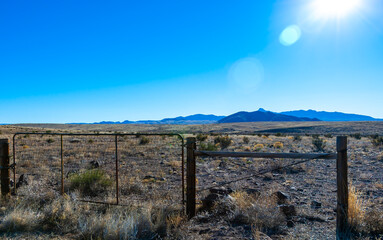 City of Rocks State Park in New Mexican Desert. View from the road with the mountains and blue sky on background