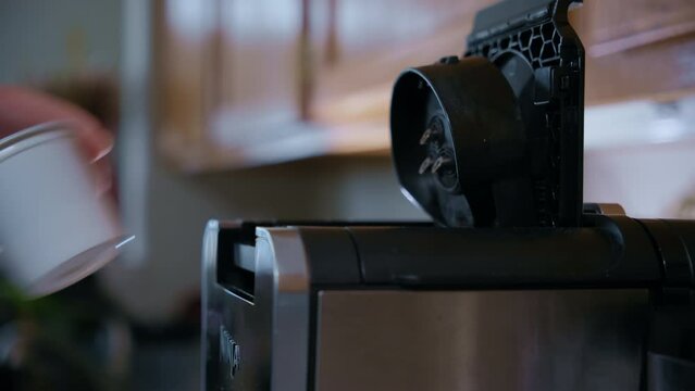 Home capsule coffee machine prepares a cup of fresh coffee. Inserting a capsule on coffee maker