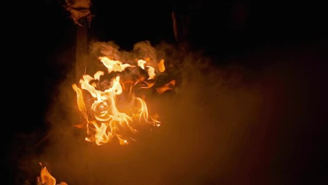 Night fire in the forest with fire and smoke.Epic aerial video of a smoking wild flame.A blazing,glowing fire at night.Forest fires.Dry grass is burning. climate change,ecology.Line fire in the dark.