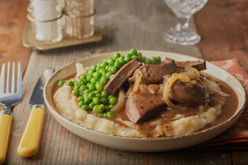 Lambs liver and onions with garden peas on a bed of creamy potatoes.