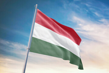 Waving flag of Hungary in blue sky. Hungary flag for independence day. The symbol of the state on wavy fabric.
