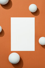 Blank paper mockup on brown background with white spheres