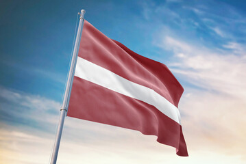 Waving flag of Latvia in blue sky. Latvia flag for independence day. The symbol of the state on wavy fabric.
