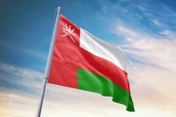 Waving flag of Oman in blue sky. Oman flag for independence day. The symbol of the state on wavy fabric.