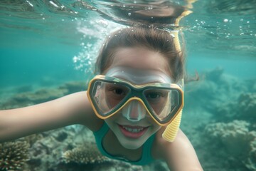 Naklejka premium Close-up of a cheerful young girl snorkeling underwater with a clear view of her face mask