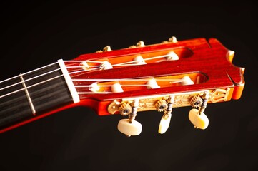 Classical Spanish flamenco guitar close up, dramatically lit isolated on black background with copy...