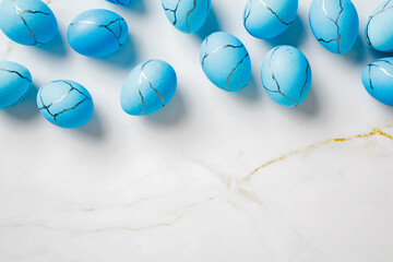 Minimal Easter background with blue eggs on stone table.