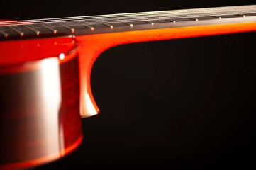 Classical Spanish flamenco guitar close up, dramatically lit isolated on black background with copy...