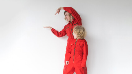 A positive blonde with a young son in red jumpsuits points to the place where your advertising text...