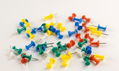 A pile of colourful pins on a white background. A set of pins.