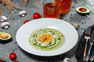 Spinach soup with croutons in white bowl