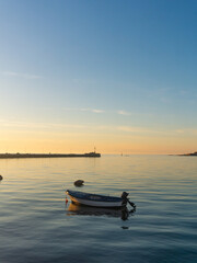 One boat and the pier of Umag at sunset
