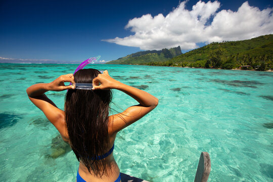 Beach travel vacation sport girl ready to snorkel in coral reefs of turquoise waters in Tahiti, French Polynesia. Image is completely unretouched. Authentic real people. Raw Image