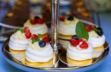 A snow-white cloud of whipped meringue with blueberries and strawberries. Pavlov's dessert. Candy bar concept.