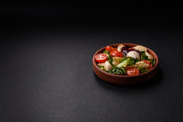 Delicious fresh caprese salad with mozzarella, tomatoes, greens with salt, spices and herbs