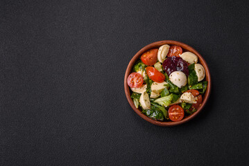Delicious fresh caprese salad with mozzarella, tomatoes, greens with salt, spices and herbs - 761759292
