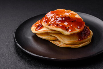 Fresh baked pancakes with delicious jam on a ceramic plate