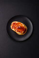 Fresh baked pancakes with delicious jam on a ceramic plate