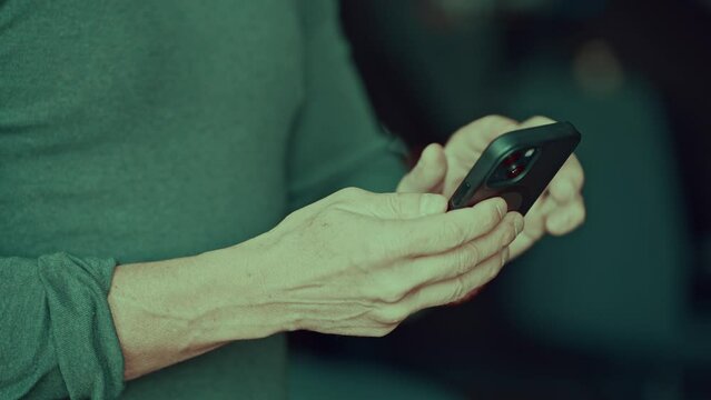 Close-up detail of a male using a cell phone for texting and messaging, fingers touching the screen. Checking email, social media, using app.