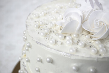 Obraz na płótnie Canvas White party cake with white icing and pearls, cake design. Handmade cake made for a special celebratory occasion. Special details.