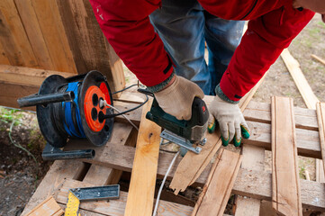 Worker sawing boards for construction - 761784695