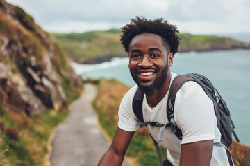 Fototapeta premium Joyful young man backpacking along a scenic seaside path