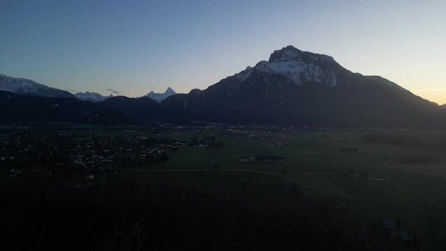 Scenic drone footage of the snowcapped Untersberg Mountain in Salzburg, Austria. Shot via drone in 4k at both sunrise and sunset. Along with the small town at the bottom of the mountain.