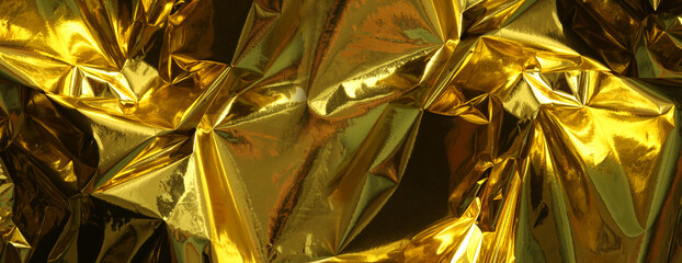 Gold and bronze foil. Abstract glow crumpled texture reflection horizonta background.