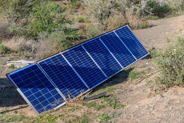 Photovoltaic solar panels on the ground on a makeshift frame in the wild.  Concept for Solar being...