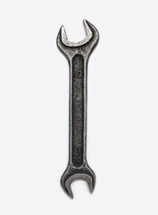 Wrench isolated on a vertical white background. One hand tool top view in the center, no people. Old and dirty metal wrench