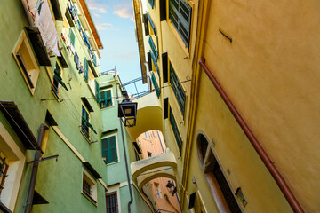 Fototapeta na wymiar Colorful area in the narrow, hillside twisting alleys, bridges and tunnels in La Pigna di Sanremo, the medieval old town of the coastal city of Sanremo, Italy in the Liguria Imperia region of Italy.