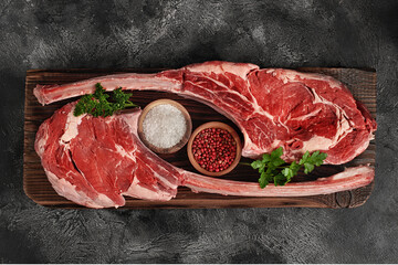 Raw tomahawk steak on wooden board - 761813234