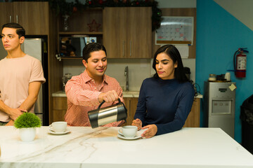Male businessman serving some coffee to a coworker during a work break