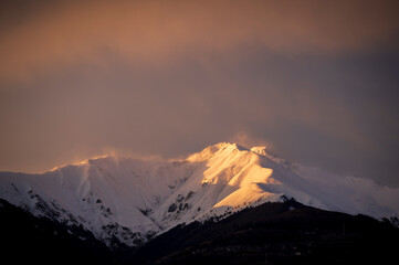 Light describe the shape of the snow capped mountain - 761815489