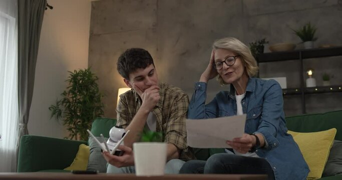 Mother and son adjust and install home cctv video surveillance camera