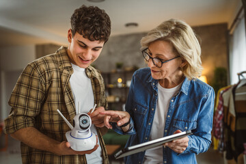 Mother and son adjust and install home cctv video surveillance camera