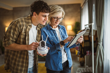 Mother and son adjust and install home cctv video surveillance camera