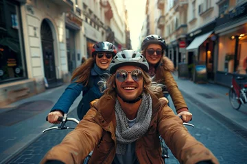 Foto op Plexiglas Three friends cycling in a narrow city street taking a selfie, enjoying urban life © Dragana