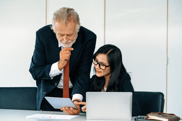 Senior executive manager and young businesswoman working in meeting room in the office. The woman...