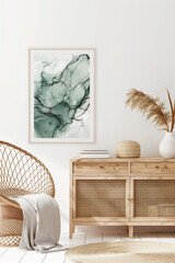 A watercolor painting of an abstract sea green marble print hung on the wall above a wicker sideboard in a white boho room with wooden flooring and natural light.