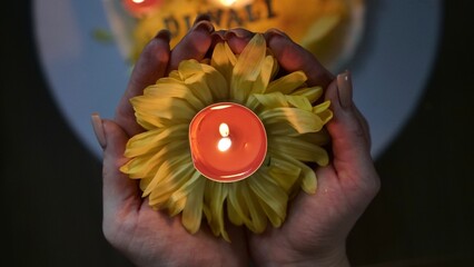 Celebration of the religious Indian festival of Diwali. Yellow flowers with burning holi candles at...
