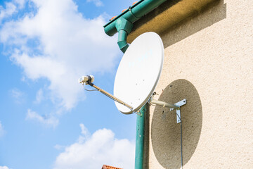 satellite dish and TV antennas on the house roof with blue sky background