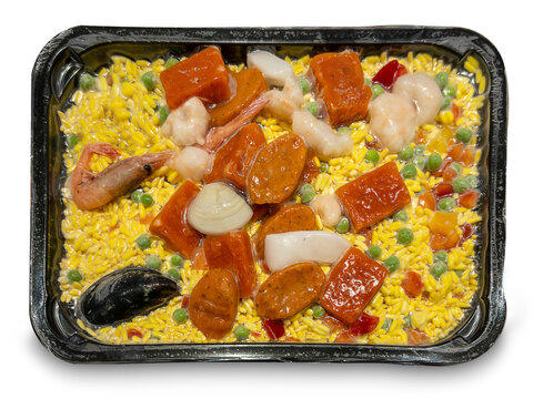 Paella with rice and precooked ingredients vacuum-packed and frozen in tray, isolated
