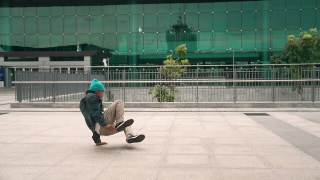 Happy hipster listen to hip hop music from headphone while dancing in lively mood. Professional street dancer perform b boy dancing at outdoor. Outdoor sport 2024. Modern lifestyle. Sprightly.