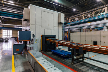 Stamping press and conveyor at metalworking factory workshop.