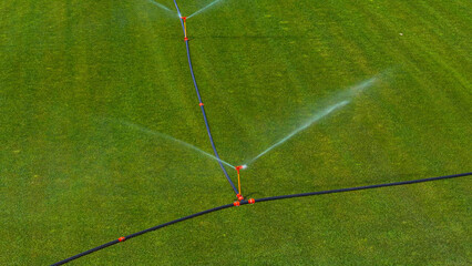 AERIAL: Sprinklers spraying fresh water to help grow sod a large industrial farm